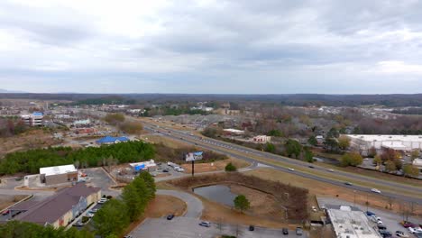 vista aérea de una ciudad suburbana con autopista y centro comercial