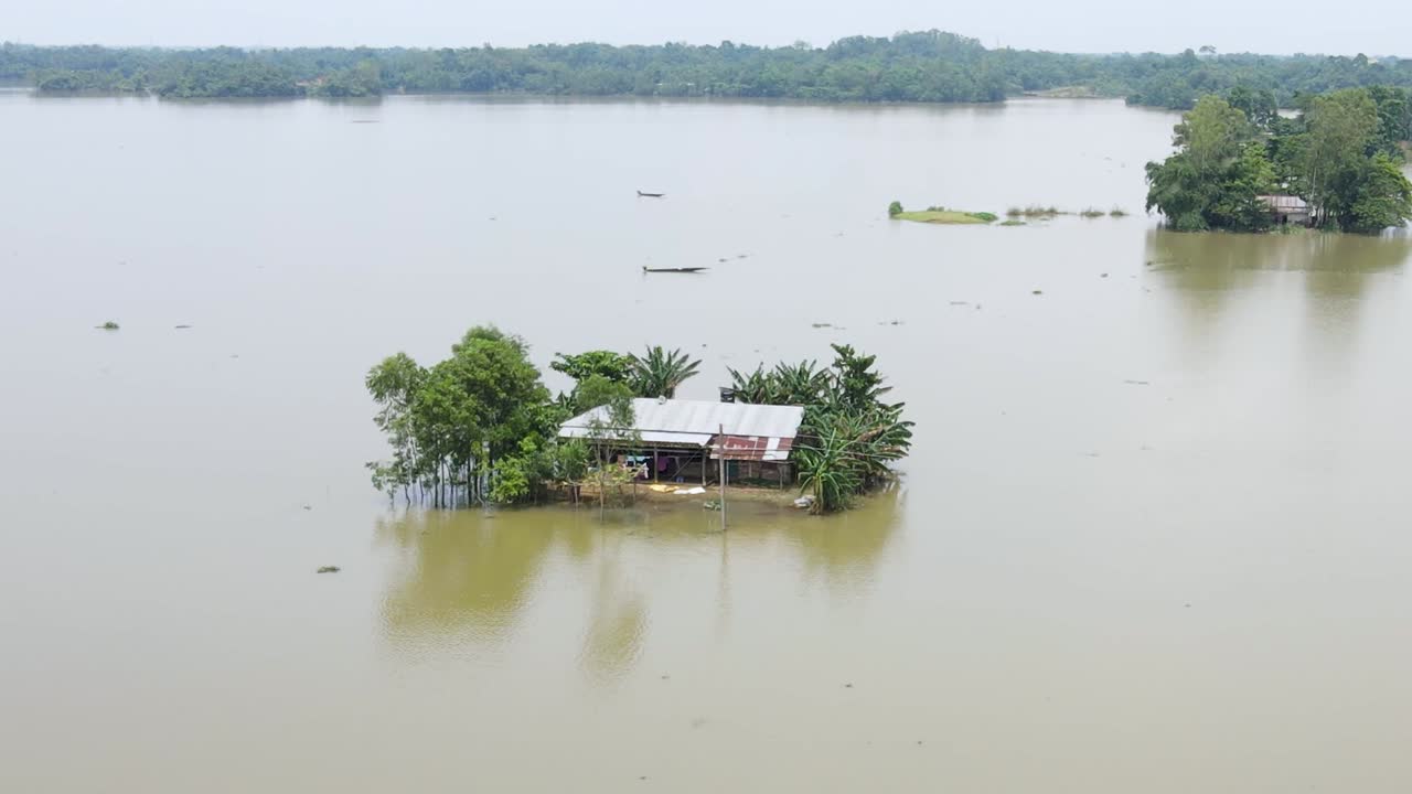 Severe flood event with extensive water covering a large area and a house partially submerged