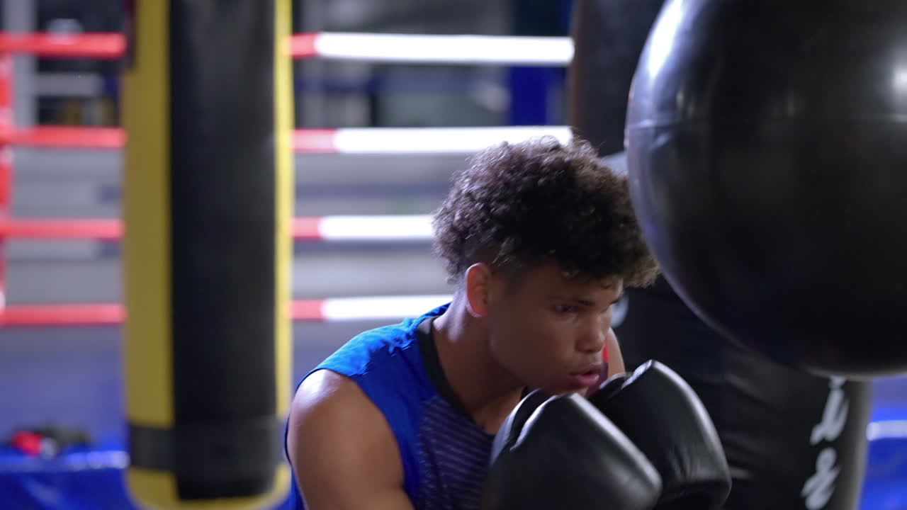 젊은 권투 선수가 권투 봉투를 가지고 훈련하고 있습니다.