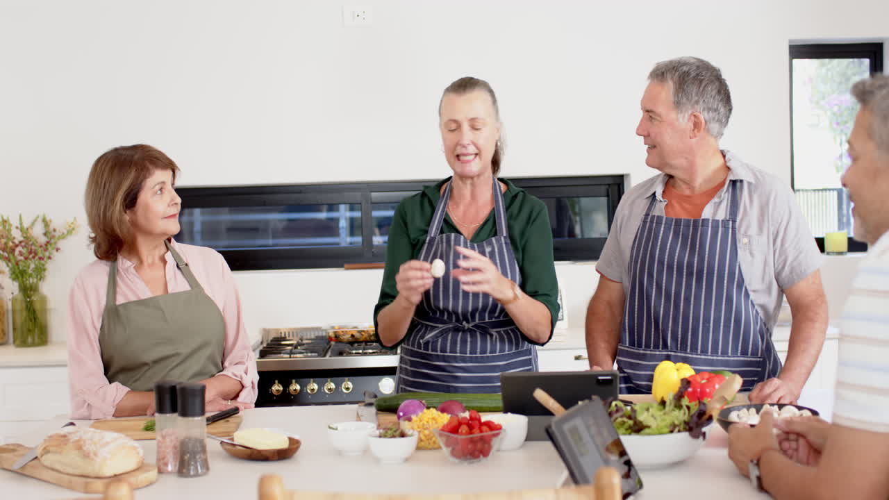 Cooking together, senior friends preparing meal with fresh vegetables in kitchen