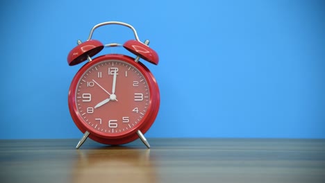 reloj despertador rojo en la mesa de madera