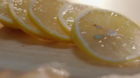 slicing lemon into thin slivers on wooden board