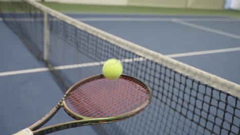 tennis ball stops on the racket