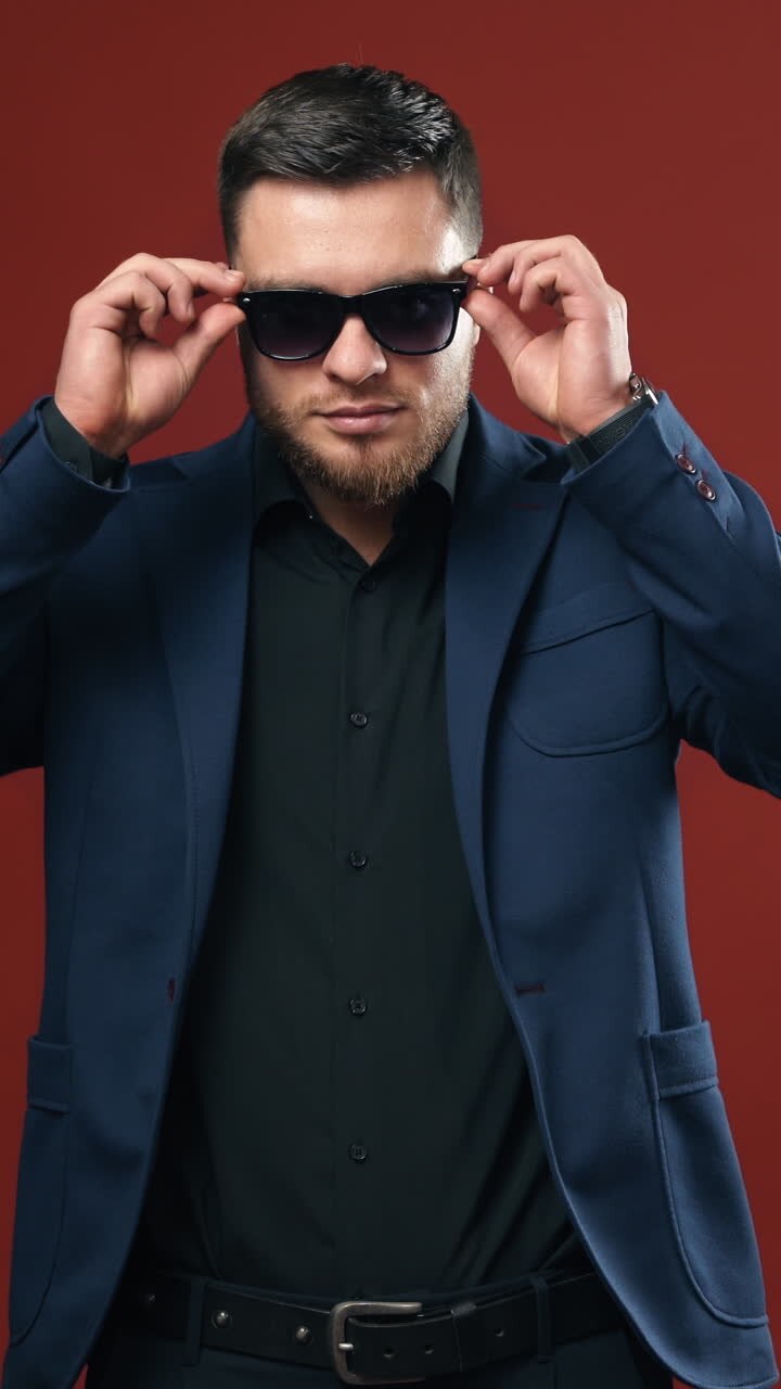 Handsome young businessman. Positive businessman wearing glasses in studio. Vertical video