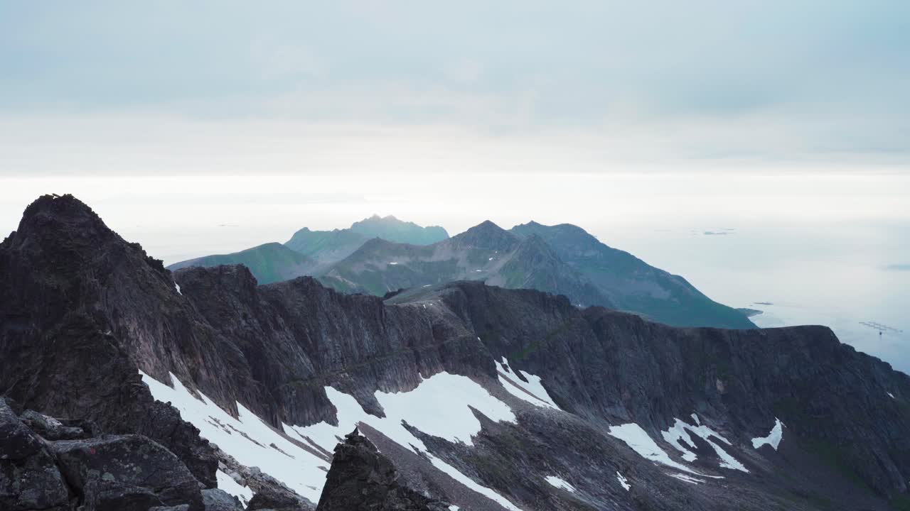 Sne på skråningen af det barske Kvaenan-bjerg på øen Senja, Norge.