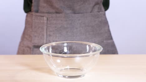 chocolate chips falling into a glass bowl