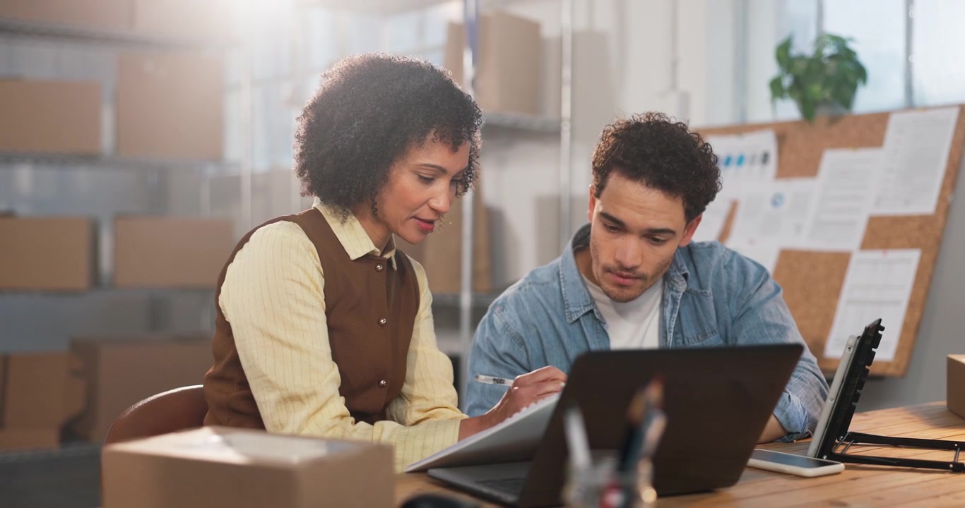 Two Colleagues Collaborating on a Project in a Warehouse Office
