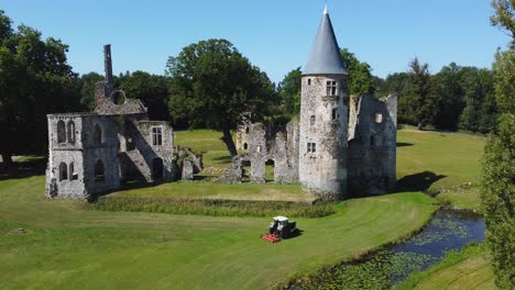 ruinas del castillo, río, tractor cortando el césped