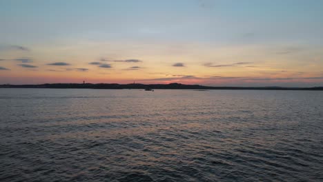 Toma-Aérea-Descendente-De-Un-Barco-En-El-Lago-Travis-Al-Atardecer