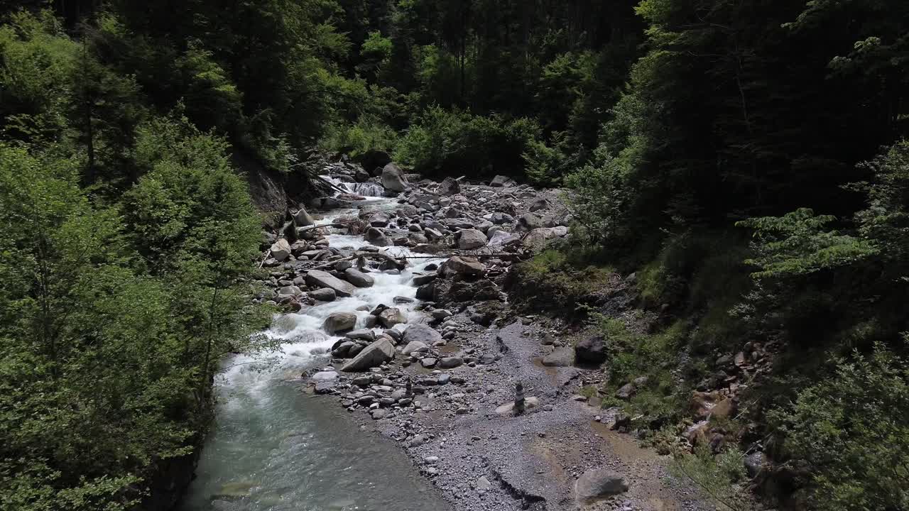 Sorvolo con drone di un fiume di montagna turchese cristallino circondato da una foresta in Austria, Europa