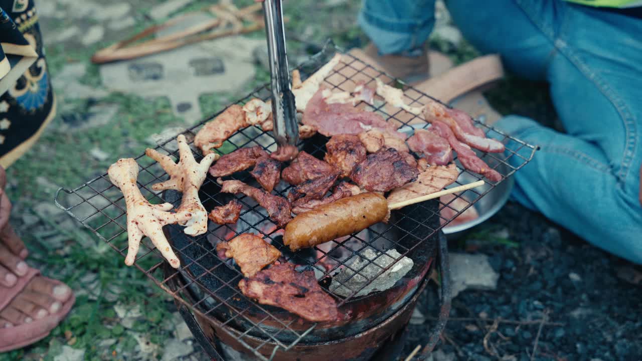Grillning av mat och kött på en grill i ett låginkomstområde i Thailand, upplyst på natten, som visar lokal gatumatlagning, vardagsliv och autentisk stadskultur