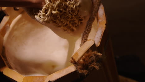 hand washing with loofah in wooden bucket