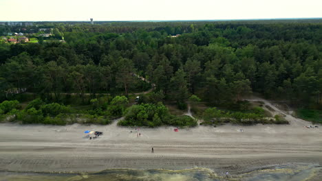 Aerial-View-Along-Green-Forested-Shoreline-On-A-Cloudy-Day