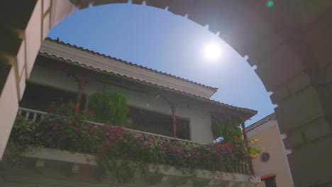 flower covered balcony framed by stone archway_cartagena colombia