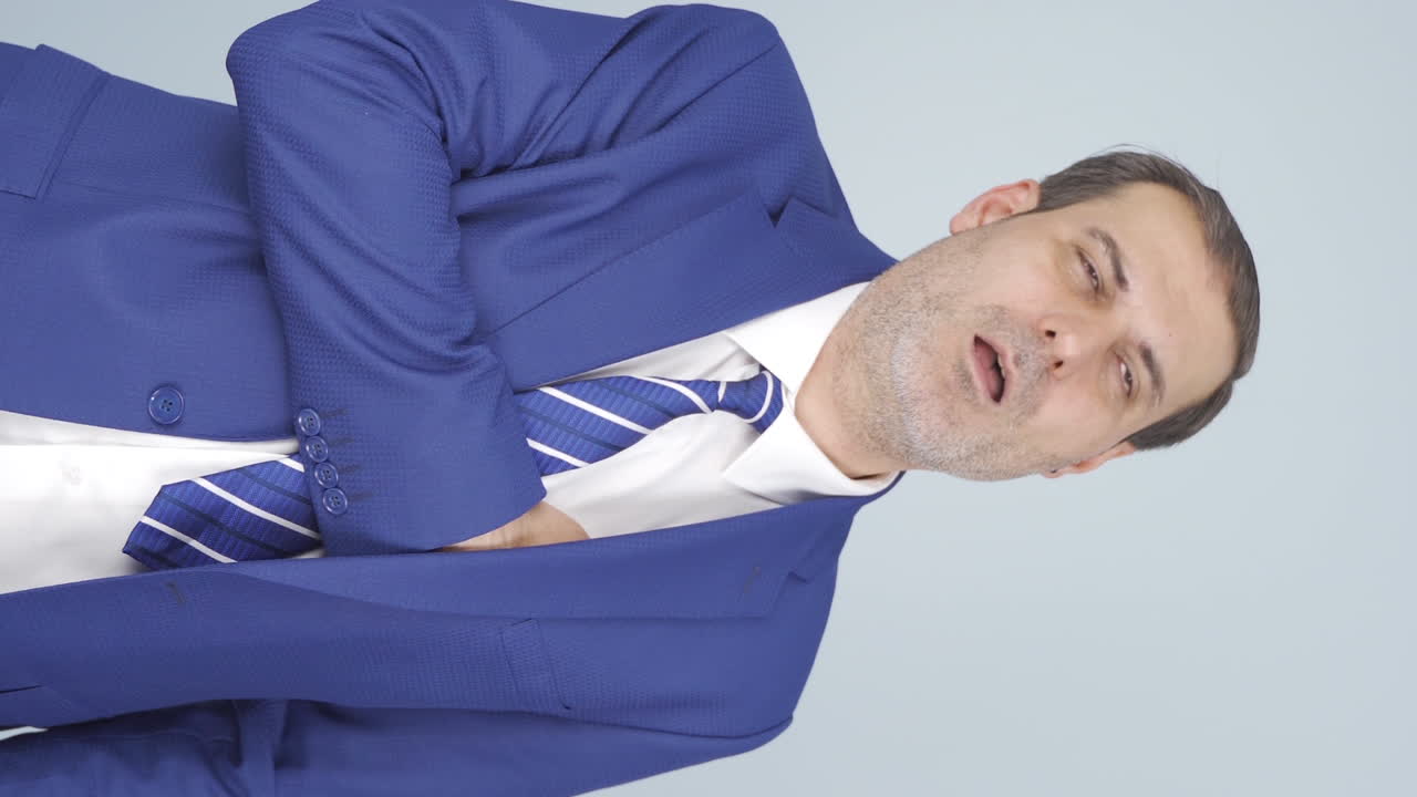 심장마비를 겪고 있는 사업가의 수직 영상입니다.