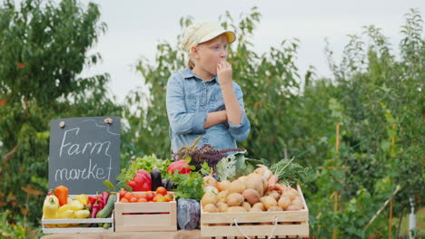 niña vendedora en el mercado de agricultores comiendo sus verduras del mostrador deliciosa organización