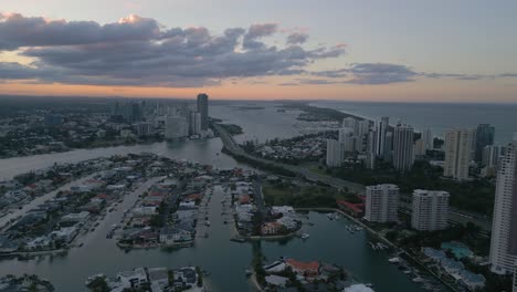 4k drone flying over the gold coast in australia at sunset with moody pinks and blues in the sky