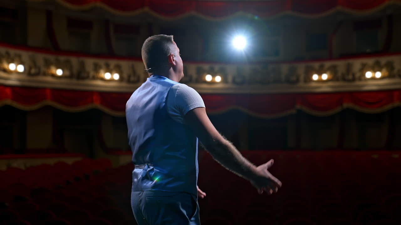 Middle age male entertainer, presenter or actor on stage. Public speaker gives performance. Man in theater.