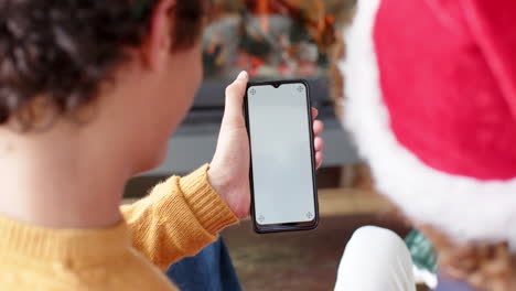 Diverse-gay-male-couple-using-smartphone-with-copy-space-for-video-call-at-home,-slow-motion