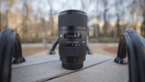 canon 10-65mm 1.8 dc lens on wooden bench