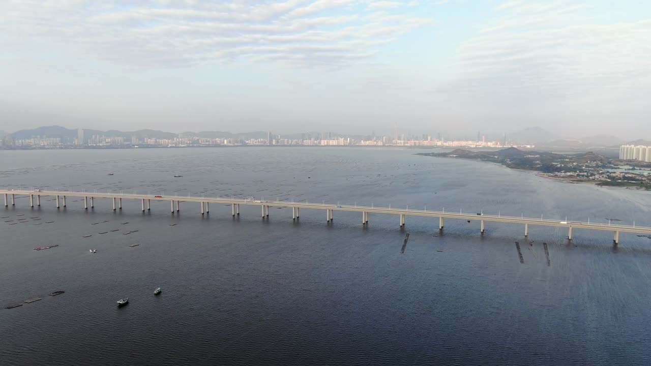 puente de la bahía de hong kong shenzhen con edificios tin shui wai en el horizonte y piscinas de cultivo de peces y ostras, vista aérea