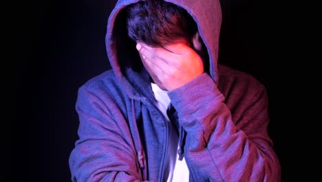 un joven con la cara en las manos