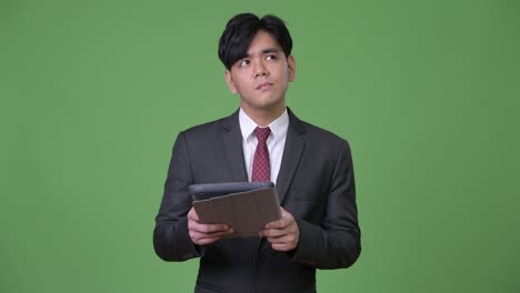 young handsome asian businessman using digital tablet