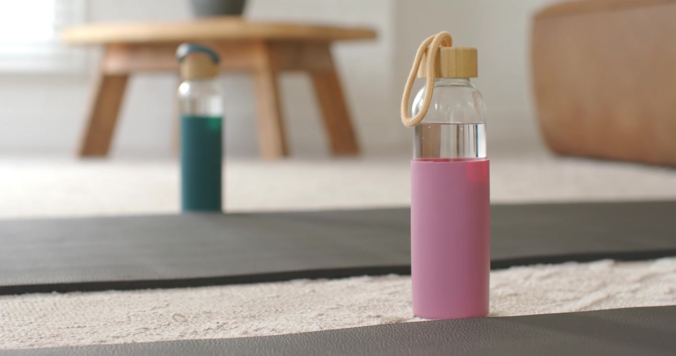 Autofocus is sharpening pink water bottle on yoga mat under soft natural light to highlight design