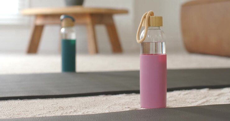 Autofocus is sharpening pink water bottle on yoga mat under soft natural light to highlight design