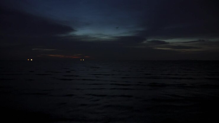 Timelapse di nuvole spettacolari sulla spiaggia mentre il crepuscolo si trasforma in notte. Nuvole veloci al tramonto che lasciano il posto a un cielo notturno scuro sopra un mare calmo.