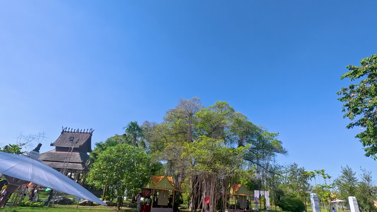 A serene outdoor scene at Rama IX Park, Thailand, with clear skies, lush trees, and a peaceful atmosphere