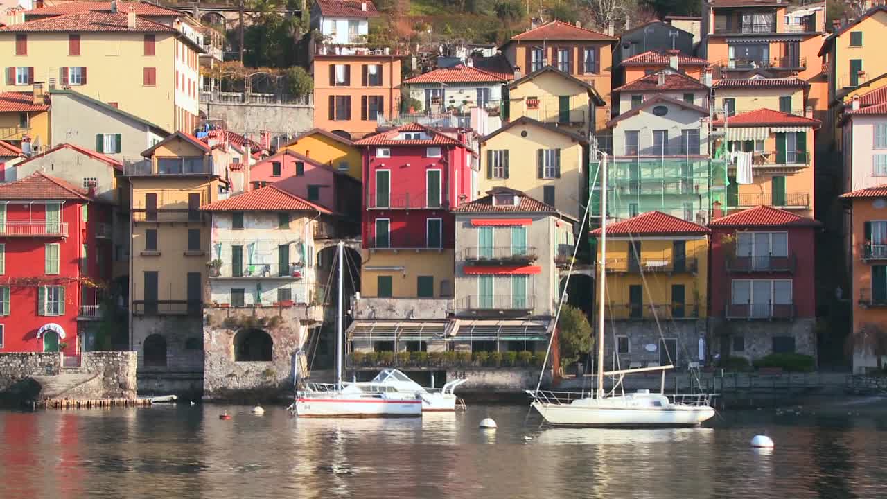 배경 2에서 바렌나 마을과 이탈리아 알프스가 있는 코모 호수 기슭의 보트에서 pov