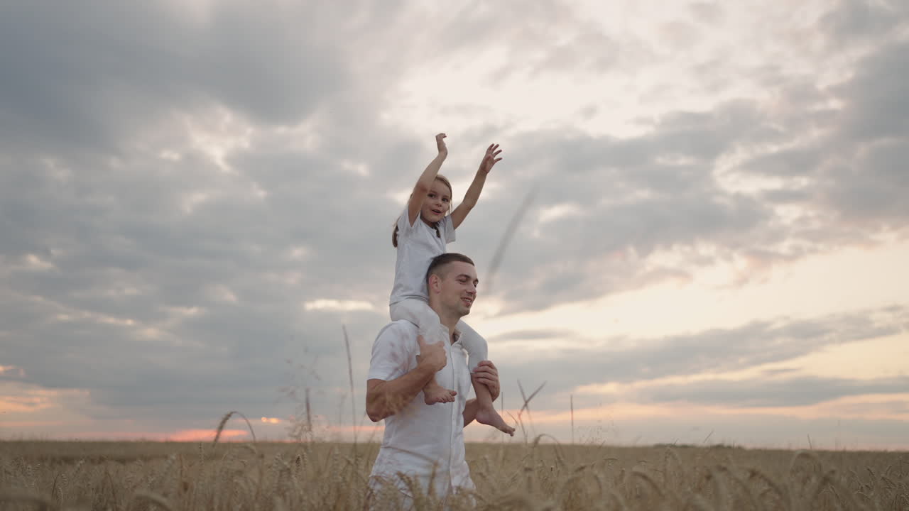 niño feliz y padre están jugando en el campo de maduración del trigo. hija pequeña en los hombros de los padres. bebé niño y padre viajan en el campo. niño y padre juegan en la naturaleza. familia feliz y concepto de la infancia