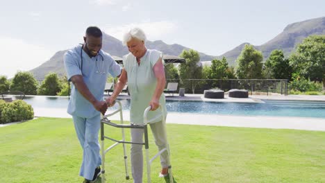 Video-of-happy-african-american-male-doctor-taking-care-of-caucasian-senior-woman-in-garden