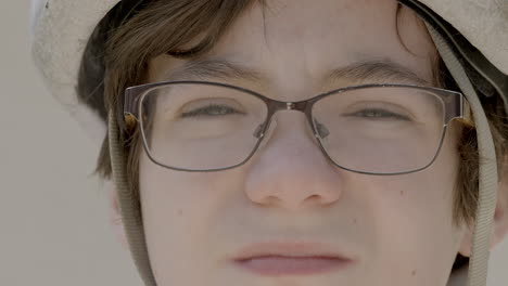 cute boy wearing a bike helmet stares into camera and then turns and leaves