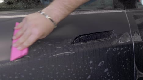 scraping liquid coating of newly wrapped car with