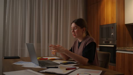mujer de negocios madura que trabaja desde casa centrada mujer está trabajando con su computadora portátil y documentos en papel sentada en la cocina en casa. aplicación de computadora portátil calcular costos gastos presupuesto estimado para el proyecto