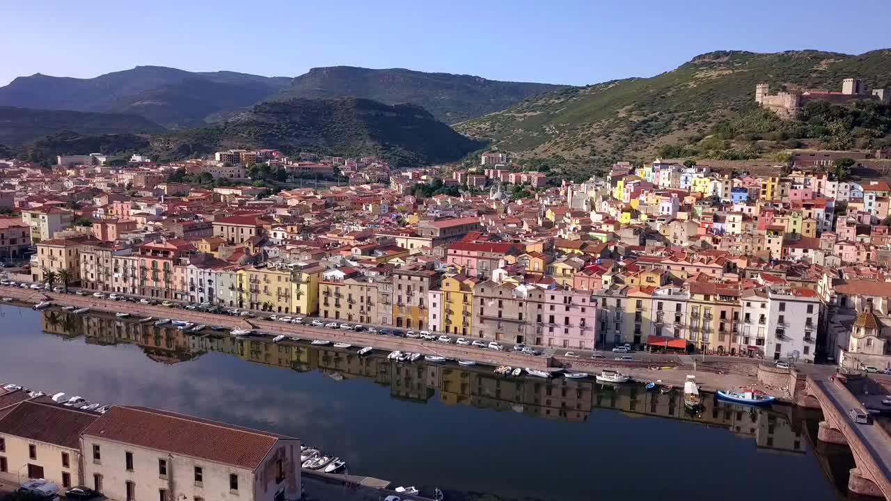 Bosa, Sardinia, Italy -Drone Arerial Shot discovering the colourful town of Bosa with a wonderful reflection on the river Temo. A typical Italian and mediterranean landscape