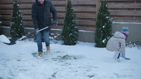 grandfather and granddaughter having fun in the snow