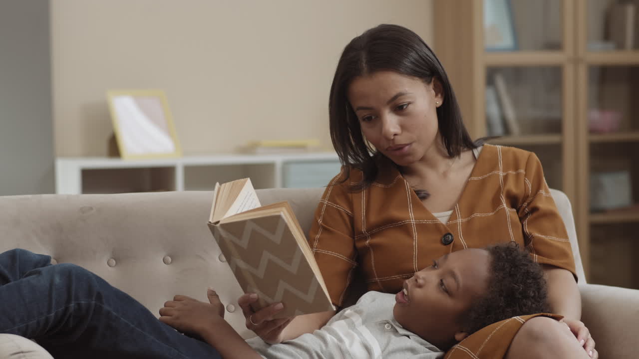 madre leyendo al niño en el sofá