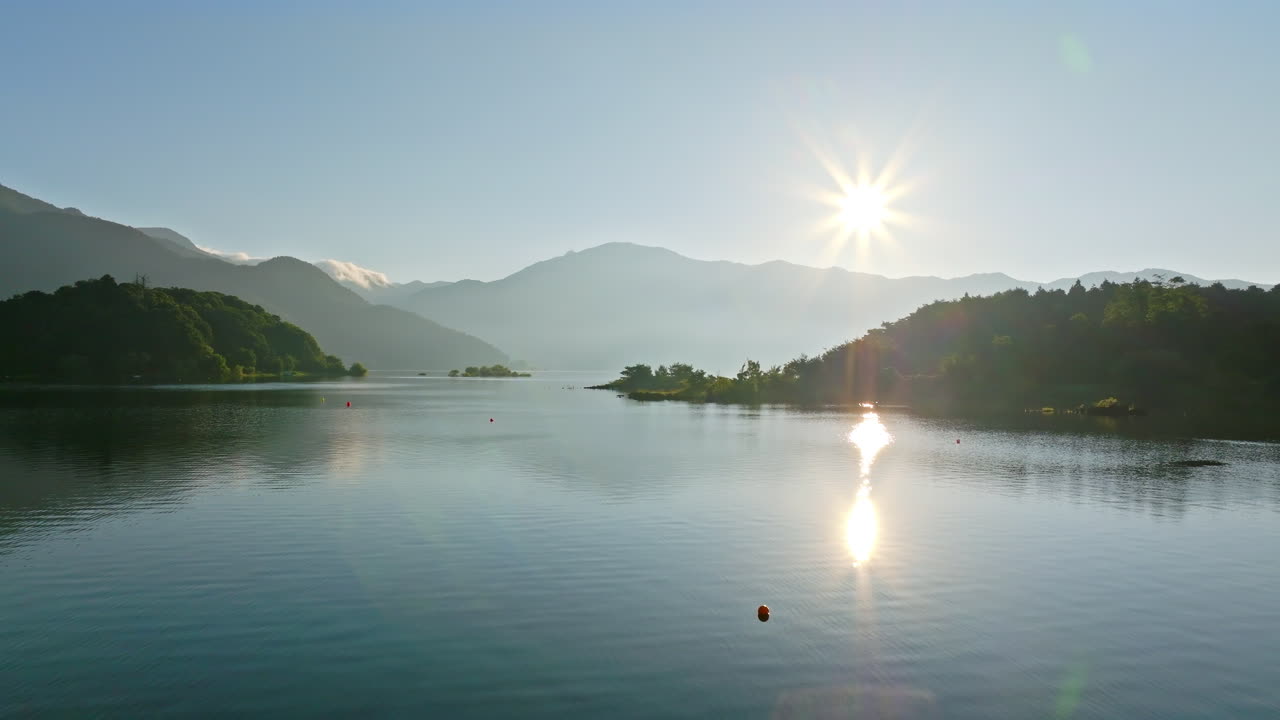 Aerial view low over the surface of Lake Kawaguchi, sunny, summer day in Japan