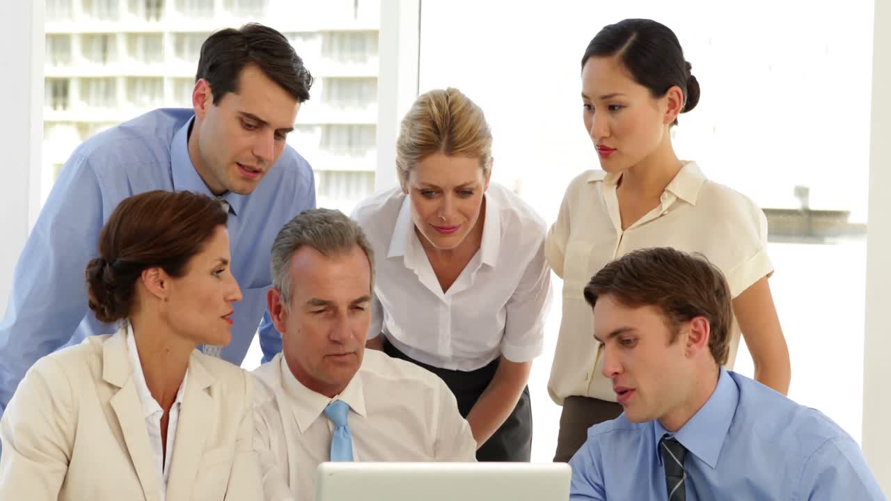 equipo de negocios sonriente trabajando frente a la computadora portátil