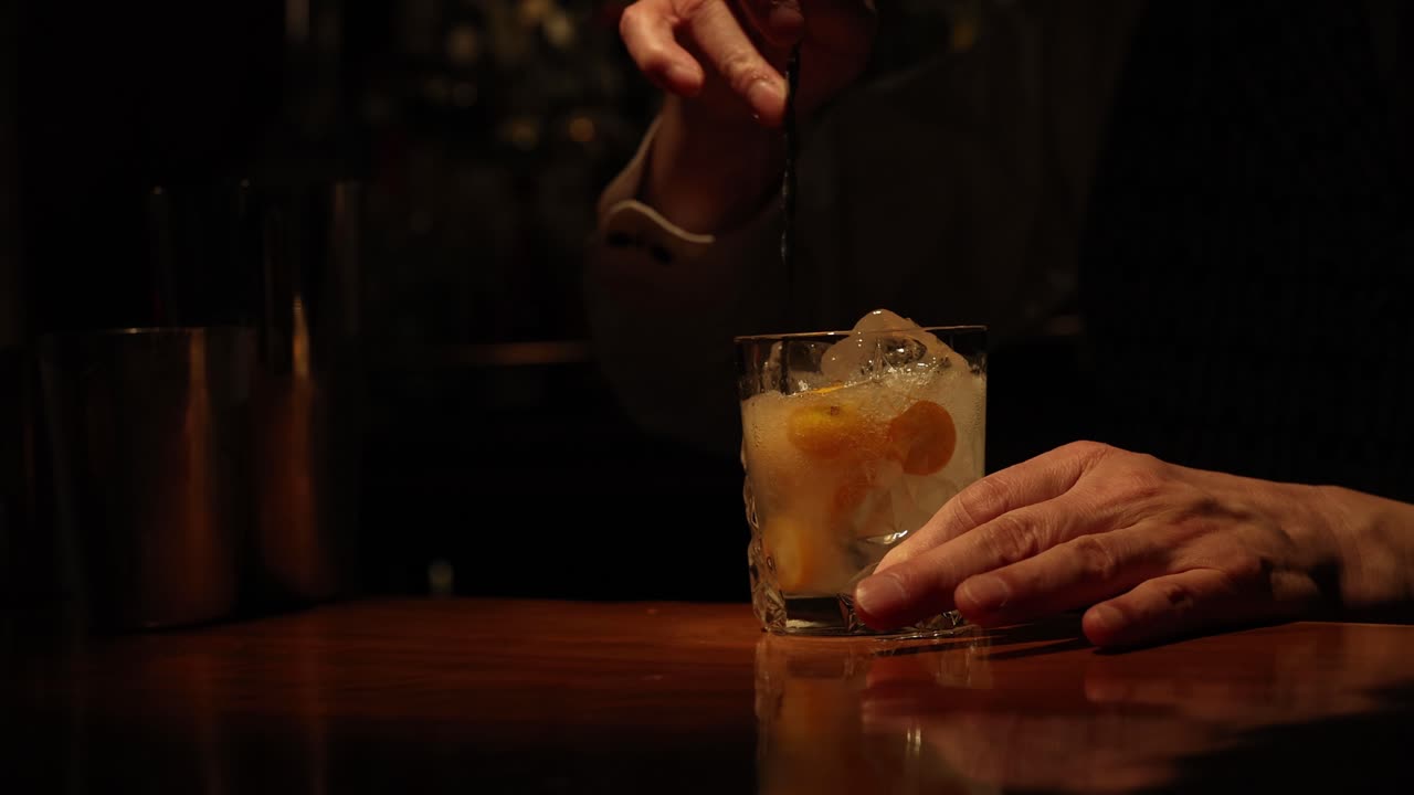 Bartender rører og serverer en cocktail