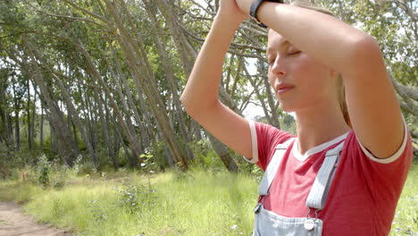 Young-Caucasian-woman-looks-into-the-distance-with-binoculars,-surrounded-by-greenery