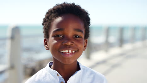 face, happy and smile of kid at beach on vacation