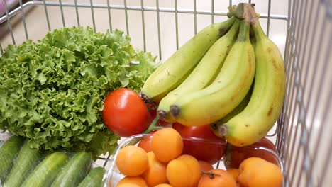 a shopping cart full of fresh fruit and vegetables