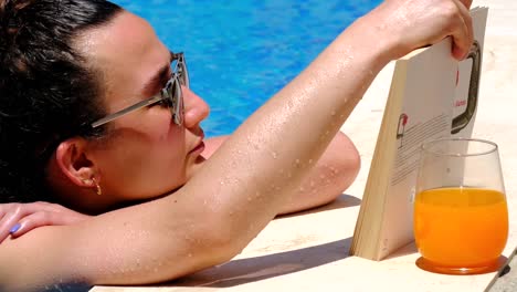 la mujer está leyendo un libro en la piscina.