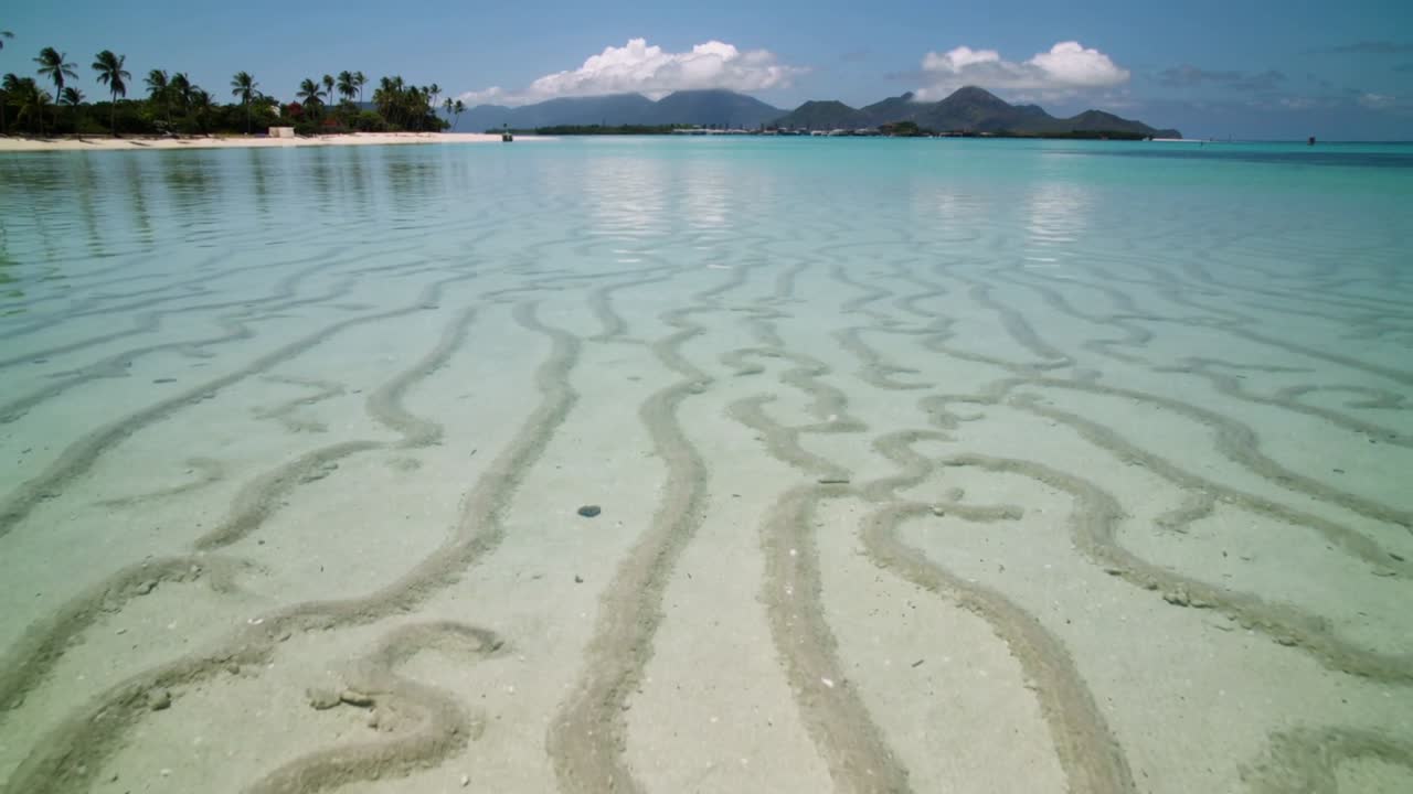 Showing shallow seabed, sand ridges and turquoise water shifting with tide and light at palm beach