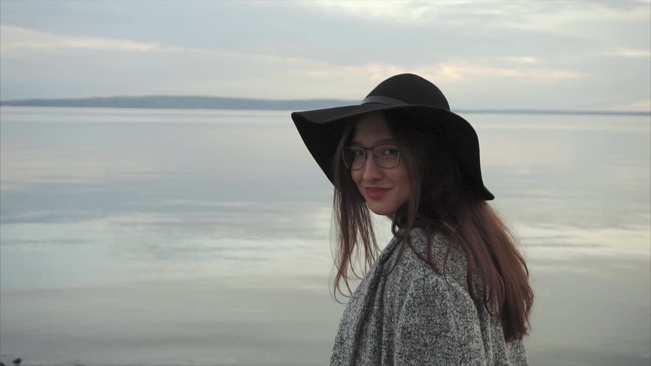 Woman in a hat by the lake