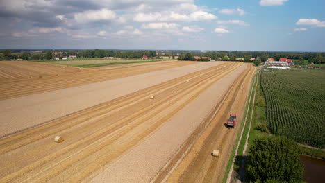 Tractor-Recogiendo-Heno-Agrícola-En-Un-Hermoso-Día-Con-Cielo-Azul-Y-Nubes